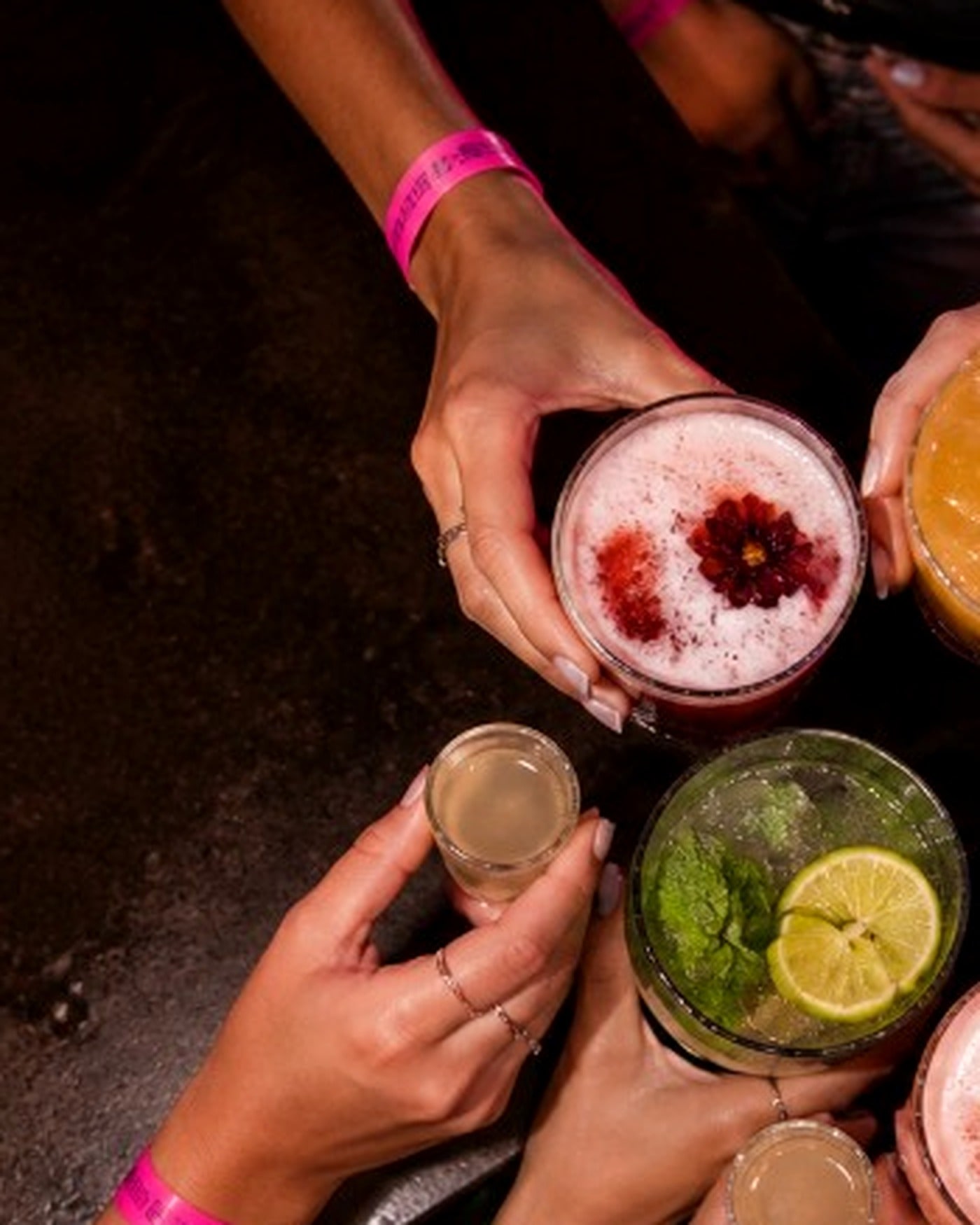 Friends toasting colourful cocktails on a Freshers night out